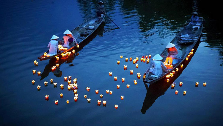 Putting flower garland down the river in Hoi An.